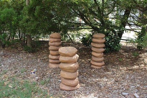 This work consists of three piles of rock-like forms set in vertical formations.