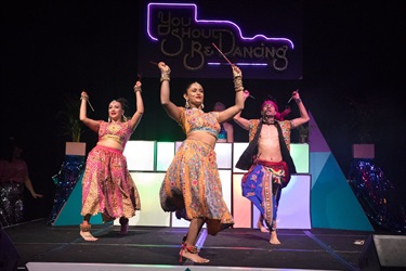 Three Bollywood dancers in traditional clothing.