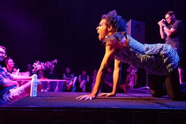 A person crawls of all fours fiercely towards the audience.