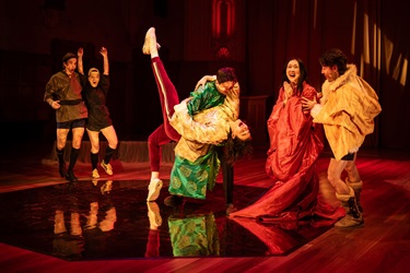 Two people dip at centre. Four others watch from the sides in excitement.