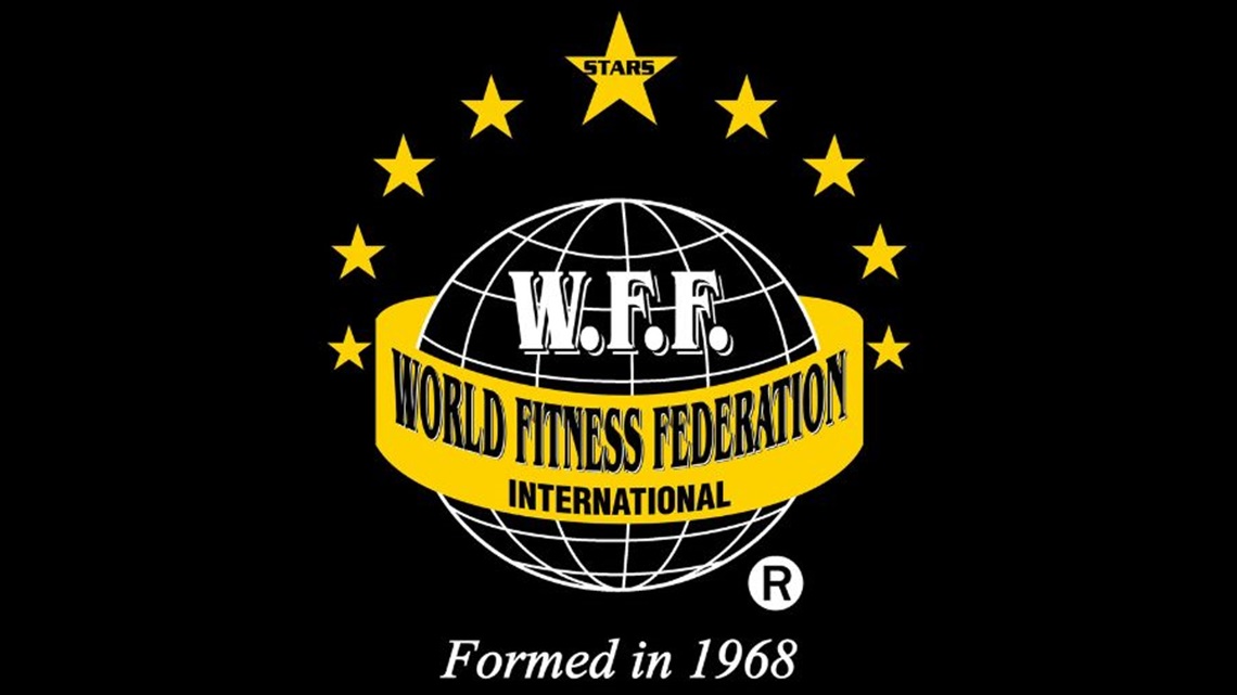 A emblem featuring a white globe with yellow stars surrounding the top half. In the centre is a gold ribbon with World Fitness Federation written on it.