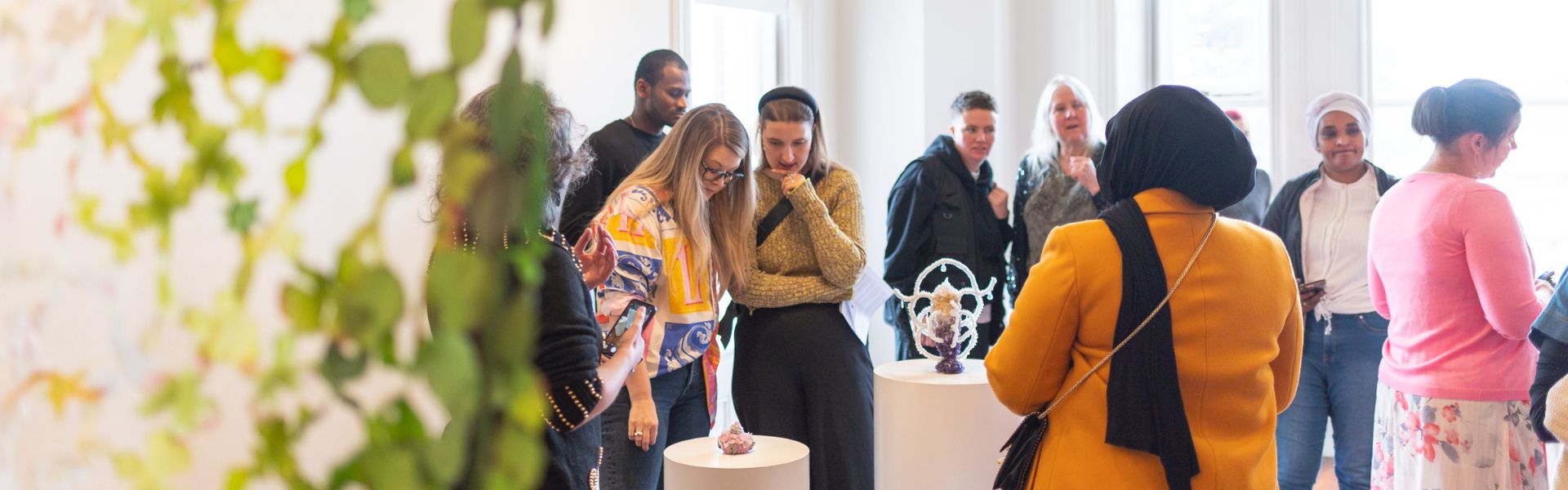 A group of people wandering through an art sculpture exhibition.