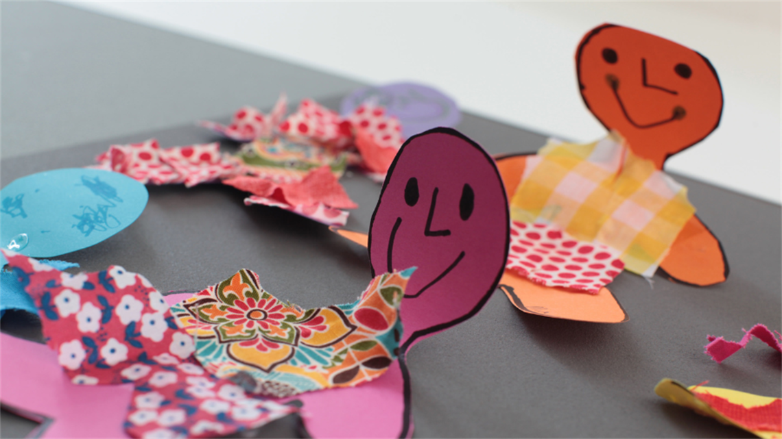 A colourful paper person with a smiley face